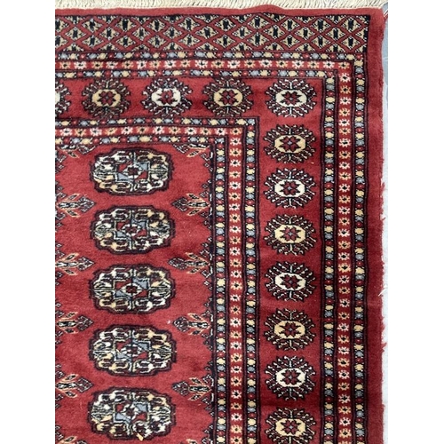 28 - Carpets & Rugs: Late 19th cent. Turkman rug, red ground with a central panel containing sixty guls a... 