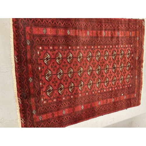 31 - Carpets & Rugs: 19th cent. Turkman rug, red ground with a central panel containing forty guls surrou... 