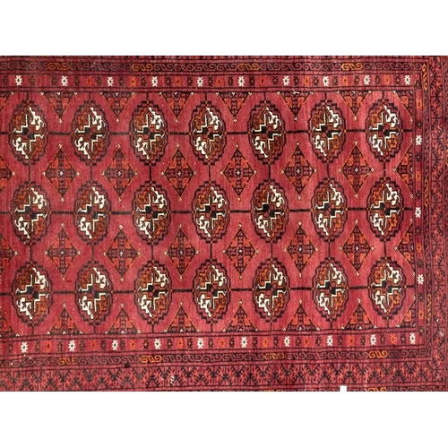 33 - Carpets & rugs: 19th cent. Turkman rug, red ground with a central panel containing forty guls, with ... 