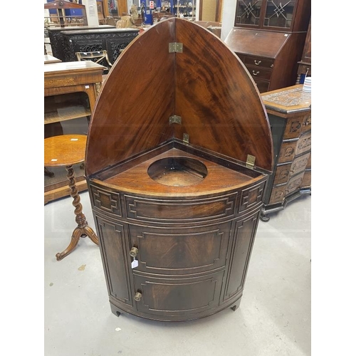 115 - Early 19th cent. Mahogany corner bow front washstand with lift up lid, two cupboard doors, brass kno... 