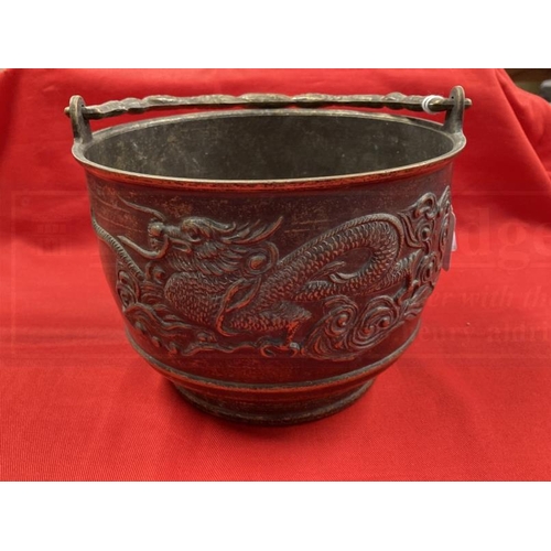 409 - Early 20th cent. Chinese bronze rice pot depicting a dragon on both sides and a shaped handle. 6ins.... 