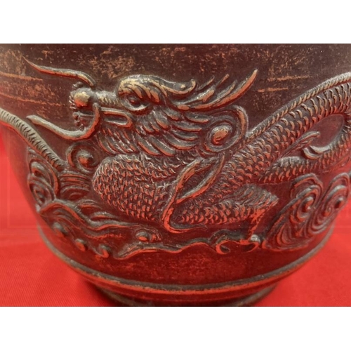 409 - Early 20th cent. Chinese bronze rice pot depicting a dragon on both sides and a shaped handle. 6ins.... 