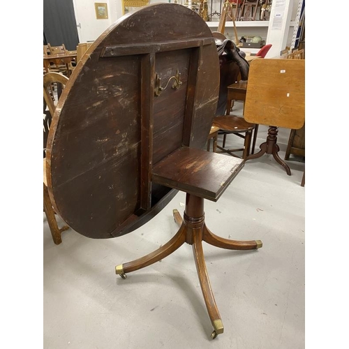 65 - Regency mahogany oval breakfast table on single column and four splayed supports. 52ins.