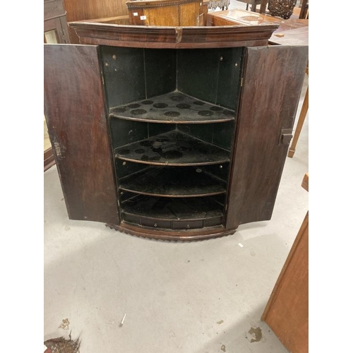 74 - Late 18th cent. Mahogany bow front corner cupboard, moulded cornice above two doors flanked by flute... 