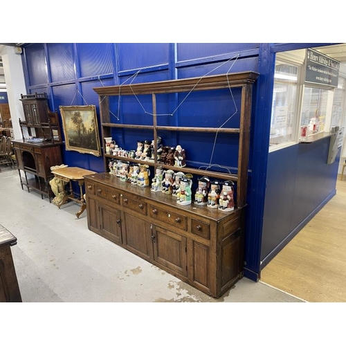 112 - 18th cent. Oak dresser with open rack, the base with five drawers over two doors and three panels, o... 