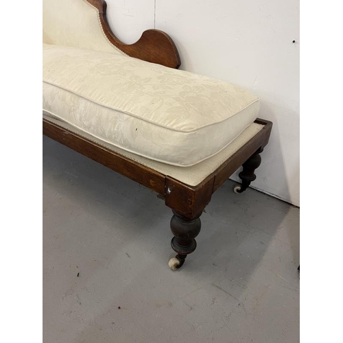 61 - 19th cent. Mahogany cream upholstered chaise on brass castors.