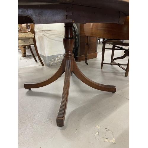 72 - Early 19th cent. Mahogany oval dining table with two flaps on a vase shaped column and 4 splay reede... 