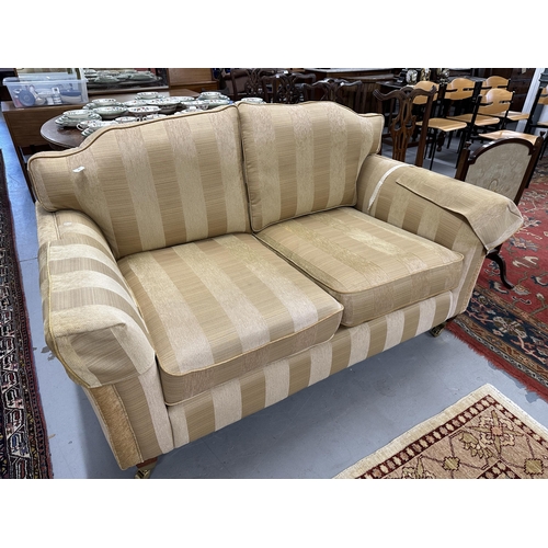 45 - 20th cent. Upholstered three-seater sofa, turned supports with cup and cover castors.