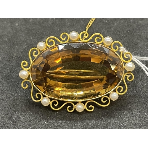 570 - Yellow metal brooch set with an oval citrine with a scroll and pearl surround, tests as 18ct gold. W... 