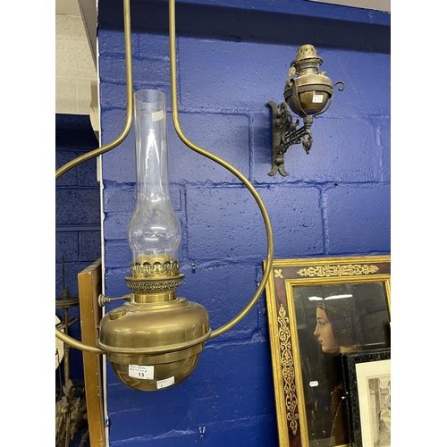 13 - Lighting: 19th cent. Hanging oil lamp, brass reservoir and hanger, plus a cast iron wall bracket con... 