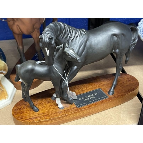 497 - Ceramics: Beswick model of Nijinsky with Lester Piggott, Black Beauty and Foal, both with oak plinth... 