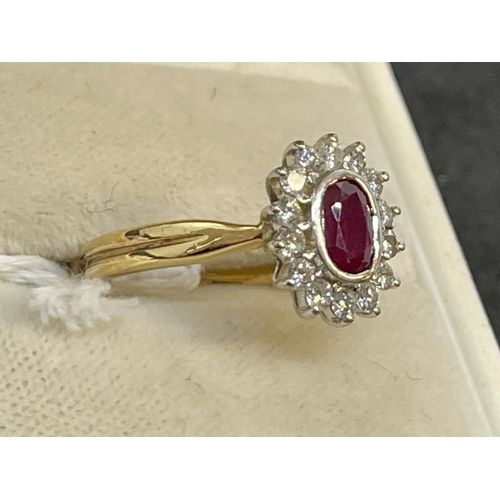 652 - Jewellery: 18ct. gold cluster ring, central ruby within a band of 14 small diamonds. 4.3g.... 