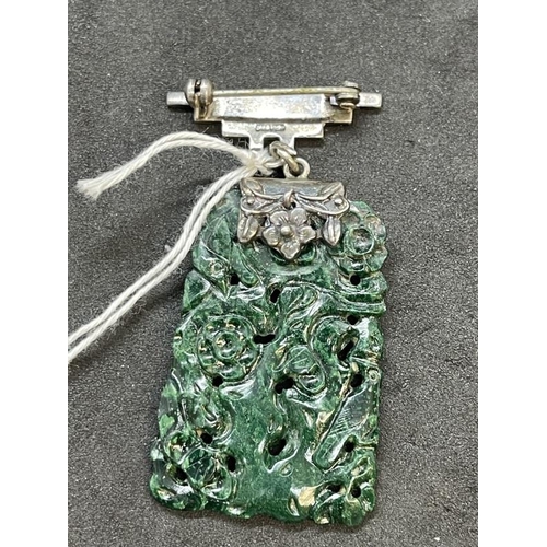 668 - Jewellery: Jade pendant, cabbage green, floral openwork carving, white metal hanger marked silver. F... 