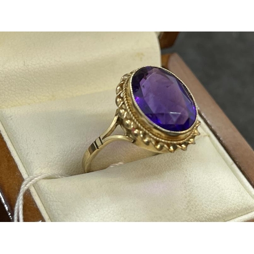 672 - Hallmarked Jewellery: 9ct gold ring set with an oval cut amethyst 15mm x 11mm having a bead and twis... 