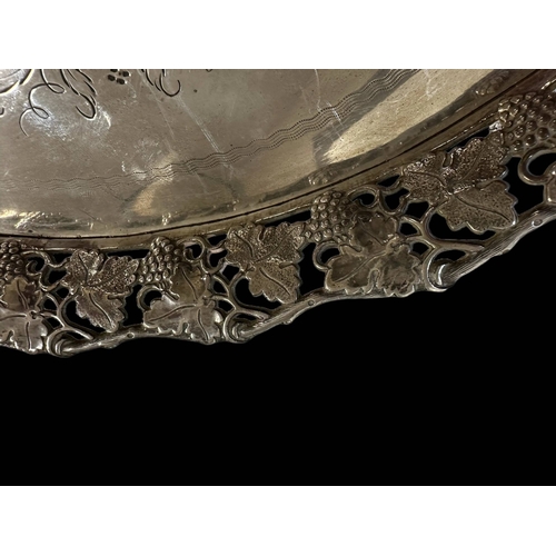 650 - Continental Silver: Round gallery tray with incised decoration and a rim cast with grapes and vine l... 