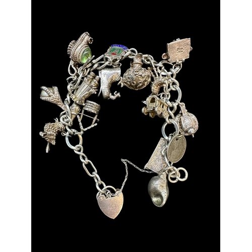 721a - Hallmarked Silver: Charm bracelet set with seventeen assorted charms. Gross weight 73g.