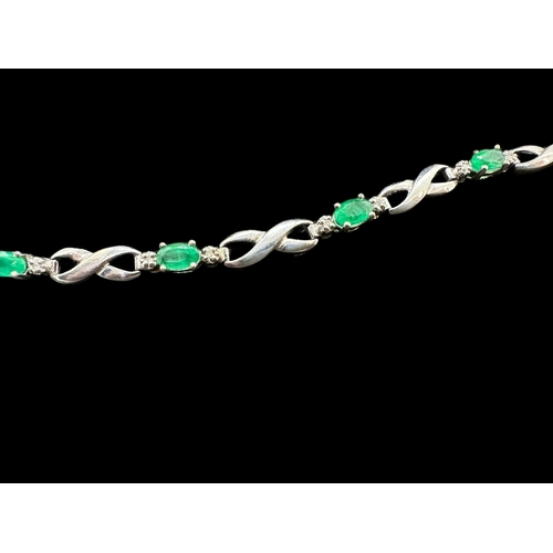 722 - Hallmarked Jewellery: 9ct white gold bracelet set with seven emeralds, each flanked by two diamonds.... 