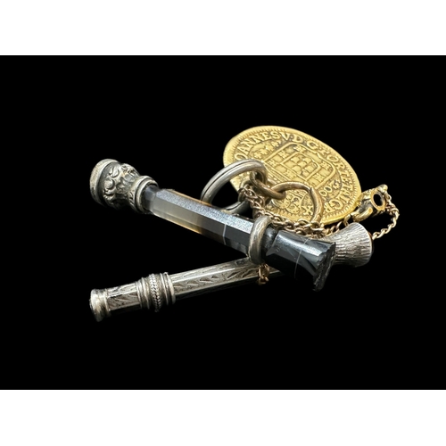 749 - Writing Requisites: Gold touch piece dated 1740, 9ct, 5.1g. Plus a silver pencil and seal.... 