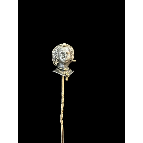 806 - Jewellery: Yellow and white metal stick pin modelled as a blackamoor wearing diamond earrings and ne... 