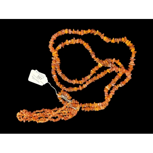 557 - Jewellery: Two amber necklets one triple row, length 18ins, and one single row opera length.... 