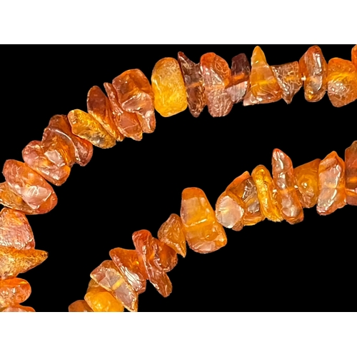 557 - Jewellery: Two amber necklets one triple row, length 18ins, and one single row opera length.... 