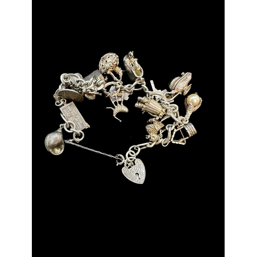 721a - Hallmarked Silver: Charm bracelet set with seventeen assorted charms. Gross weight 73g.