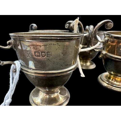 723 - Hallmarked Silver: Hallmarked Silver: Set of four egg cups with c scroll handles, hallmarked London.... 