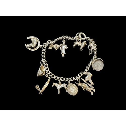 730a - Jewellery: White metal tests as silver charm bracelet and 12 novelty charms.