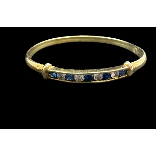 780 - Hallmarked Jewellery: 14ct gold bangle set with alternating blue and white synthetic sapphires, mark... 