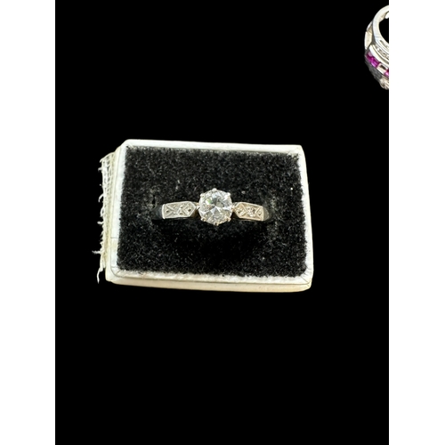 823 - Hallmarked Jewellery: 18ct white gold ring set with a central diamond, each shoulder with a smaller ... 