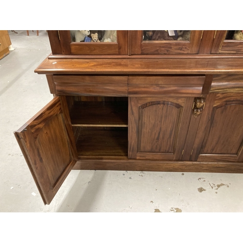 83 - Furniture: 20th cent. Mahogany bookcase with four glazed doors above a base with four drawers and cu... 