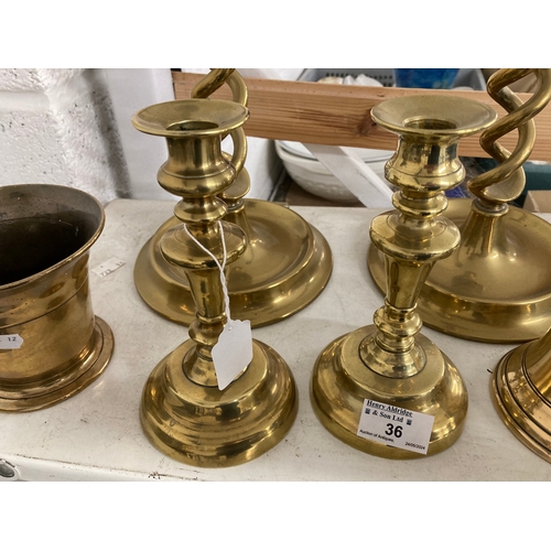 36 - Brass candlesticks open twist on cast base, 20ins. Plus a small pair, 7ins.