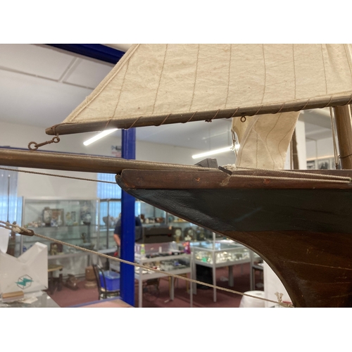 68 - Toys & Games: Treen racing pond yacht fully rigged, red hull, racing keel, on stand. 128cm x 118... 