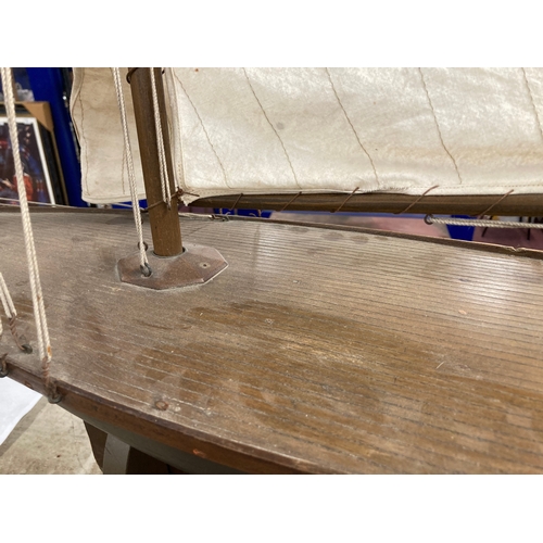 68 - Toys & Games: Treen racing pond yacht fully rigged, red hull, racing keel, on stand. 128cm x 118... 