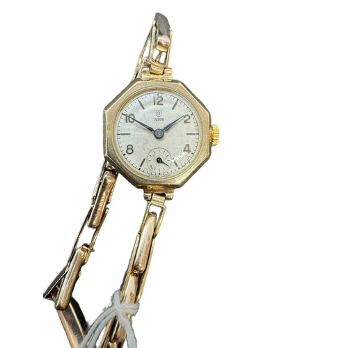 884 - Watches: Ladies 9ct. gold Tudor wristwatch on expanding gold strap, Chester 1949. The octagonal head... 