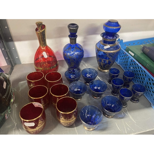 259 - Glassware: Murano red glass decanter and six glasses, gilt decorated, a Murano blue glass decanter x... 