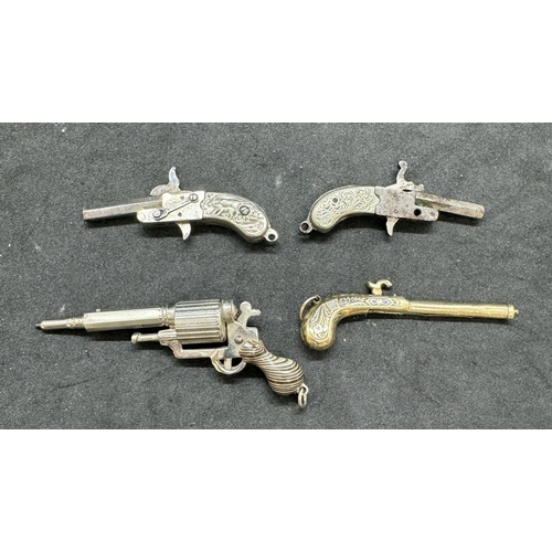 731a - Two pocket pins and two propelling pencils in the form of miniature pistols.