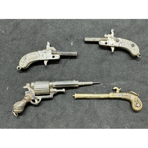 731a - Two pocket pins and two propelling pencils in the form of miniature pistols.