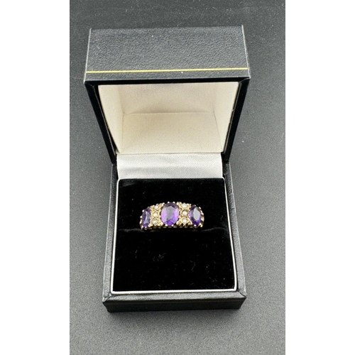 820 - Jewellery: A 9ct gold ring, partially hallmarked, set with three amethysts divided by six seed pearl... 