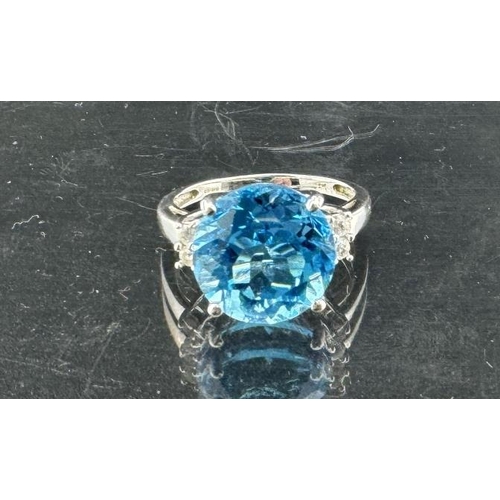 821 - Jewellery: A 9ct white gold ring, a central 12mm round topaz flanked by two white stones on each sho... 