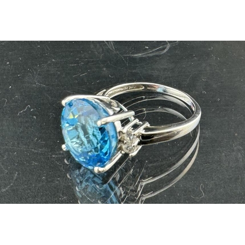821 - Jewellery: A 9ct white gold ring, a central 12mm round topaz flanked by two white stones on each sho... 