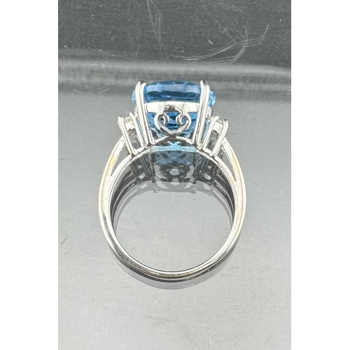 821 - Jewellery: A 9ct white gold ring, a central 12mm round topaz flanked by two white stones on each sho... 