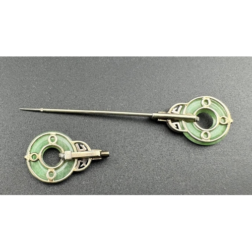 822 - Jewellery: Early 20th century white metal cloak or dress pin, each end a pierced jade disc held in p... 