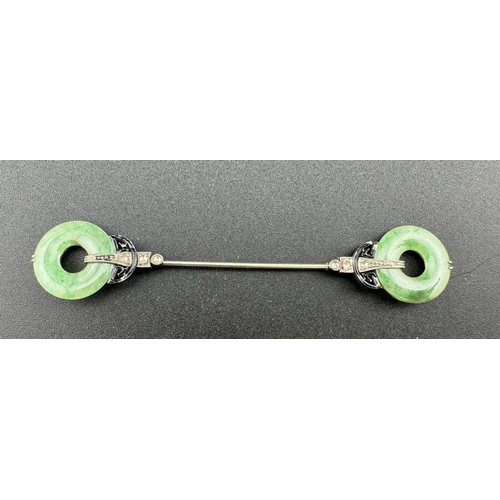 822 - Jewellery: Early 20th century white metal cloak or dress pin, each end a pierced jade disc held in p... 