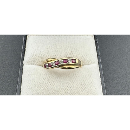 823 - Jewellery: A 9ct yellow gold crossover ring, set with a row of alternating diamonds and rubies, toge... 