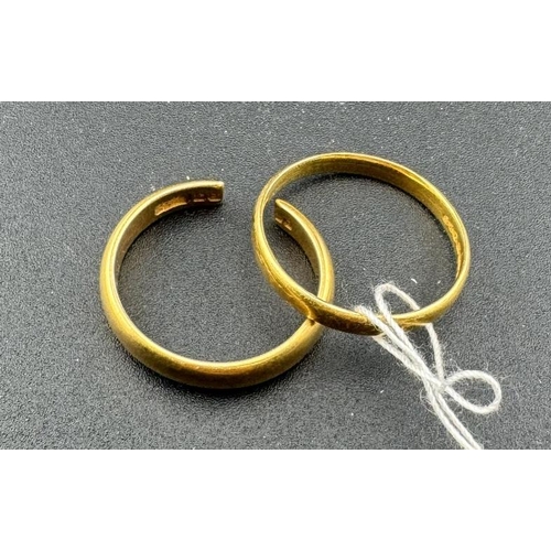 824 - Jewellery: Two 22ct yellow gold wedding bands, one cut. Combined weight 10.4g.