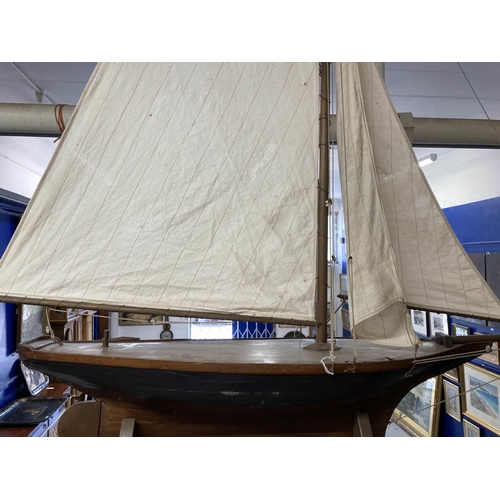 98 - Toys & Games: Treen racing pond yacht fully rigged, red hull, racing keel, on stand. 128cm x 118... 