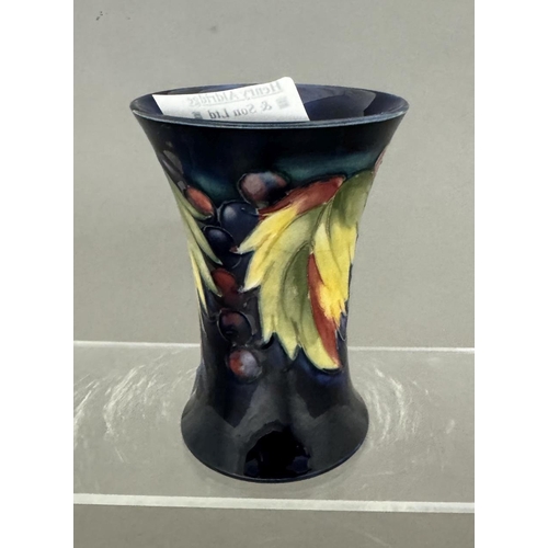 576 - Ceramics: Ceramics: A Moorcroft Pottery trumpet vase painted in the Leaf & Berry pattern to a de... 