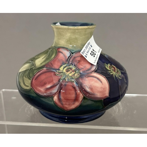 581 - Ceramics: Ceramics: A Moorcroft Pottery squat vase painted in the Clematis pattern to a green ground... 