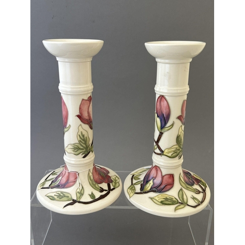 592 - Ceramics: Ceramics: Moorcroft Pottery Magnolia pattern candlesticks, polychrome decorated to a white... 